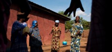 Female members of a village committee in South Kivu dance around a women's center. Photo by Lynsey Addario